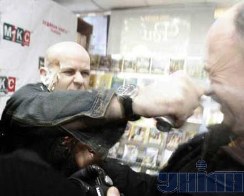 Олесь Бузина успокаивает газом хулигана, который пытается отбить у него взятую в плен Сашу Шевченко